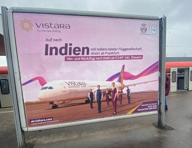 On a train platform in Frankfurt, there is a large billboard. It showcases the image advertising of the airline AirVistara.