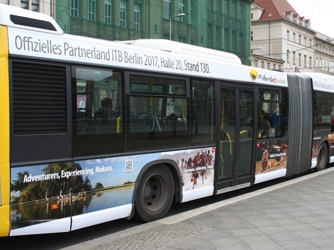 a long bus, covered in a ooh (out of home) ad for the ITB, a trade fair in Berlin.