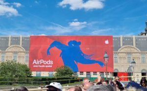 Giant Poster Ad for AirPods in red and blue on a large facade.