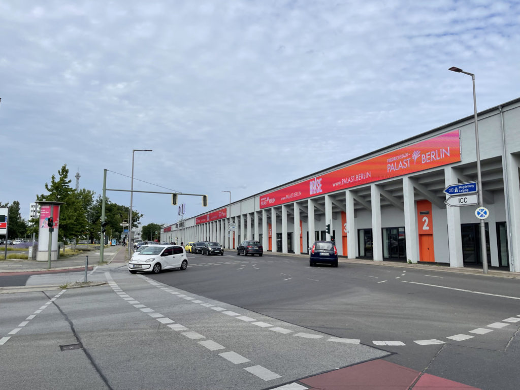 Big building of the messe berlin with advertising on the side by Friedrichstadt Palast Berlin