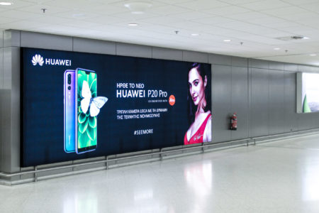 A long, extended Huawei billboard for the new P20 Pro phone model stretches along a wall at Athens airport.