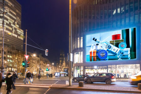 On a large digital LED wall on a building on Kurfürstendamm in Berlin, at night, you can see advertising from 'Beluga Vodka International Limited'