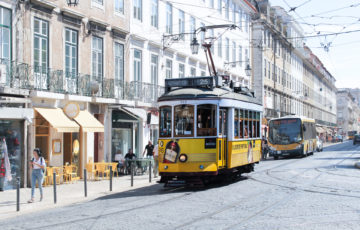 In the neighborhood of Lisbon, you can see a tram with advertising for 'Beirao.