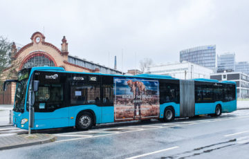A bus with a traffic board format is traveling through Oslo, advertising office rental.