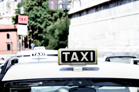 A taxi stand in Rome with a black and yellow taxi sign.